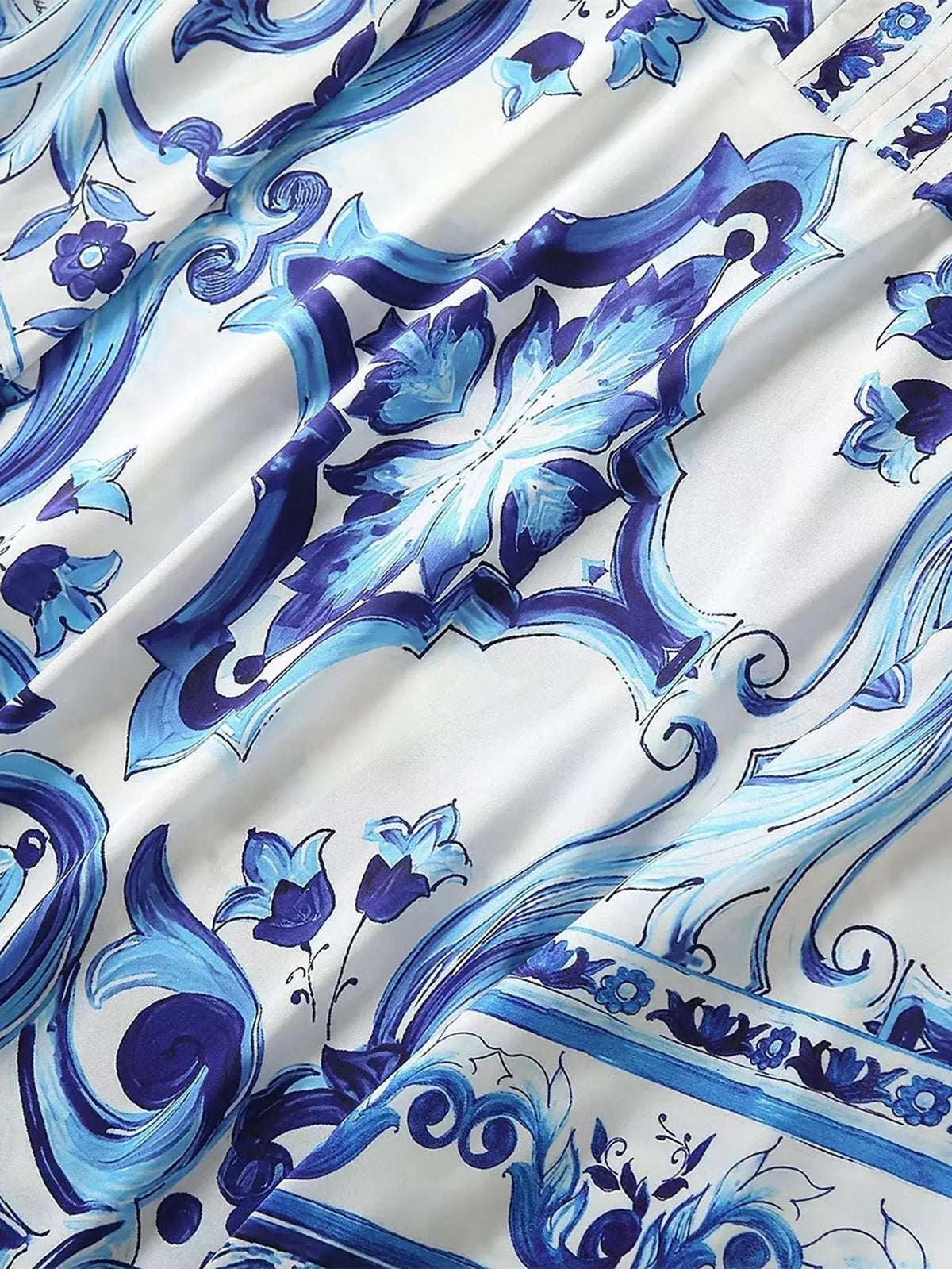 Elegant blue and white floral print fabric, featuring intricate designs on smooth silk material. Perfect for stylish garments.