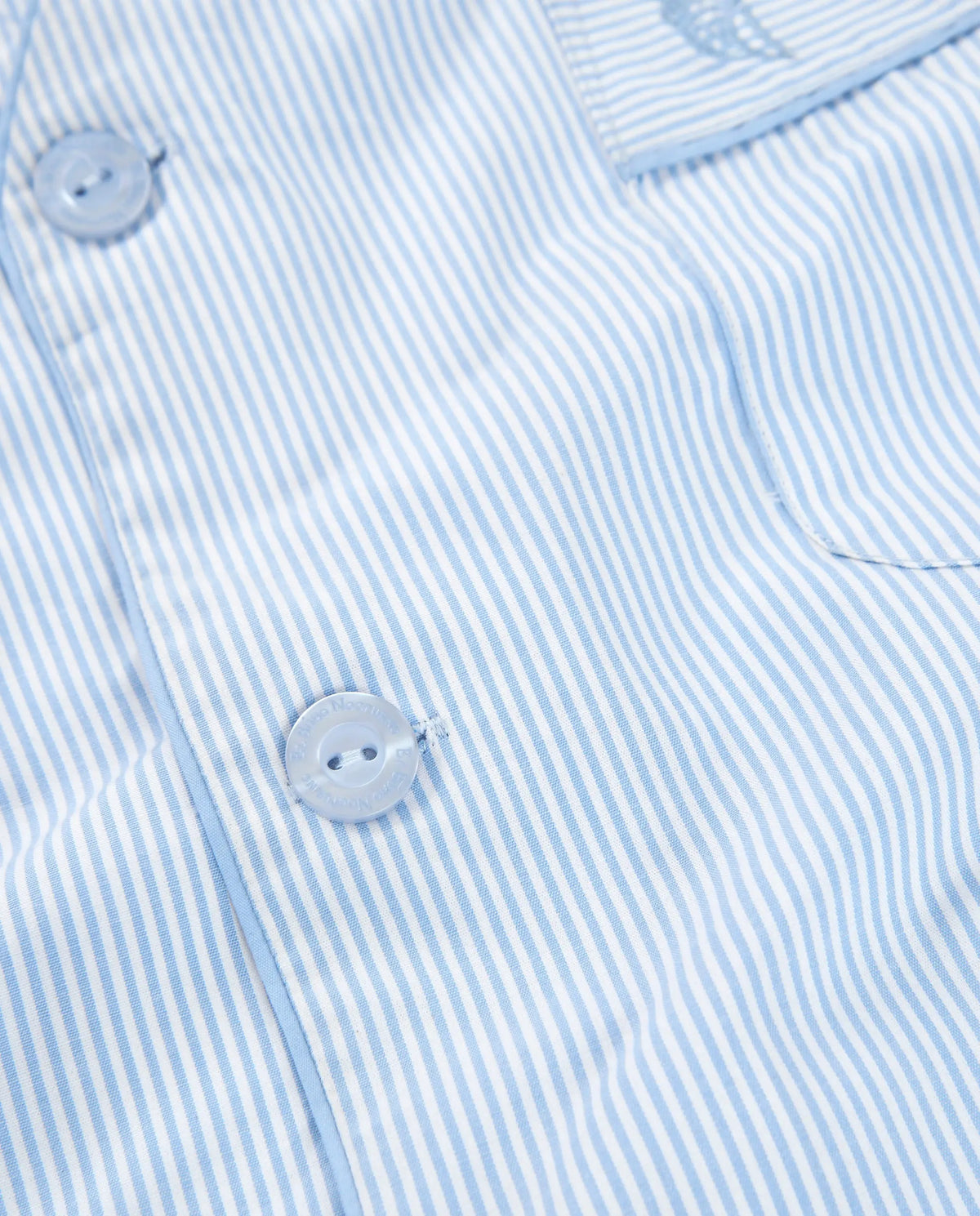 Camisa de rayas azul claro y blanco, algodón suave, estilo casual con botones transparentes.
