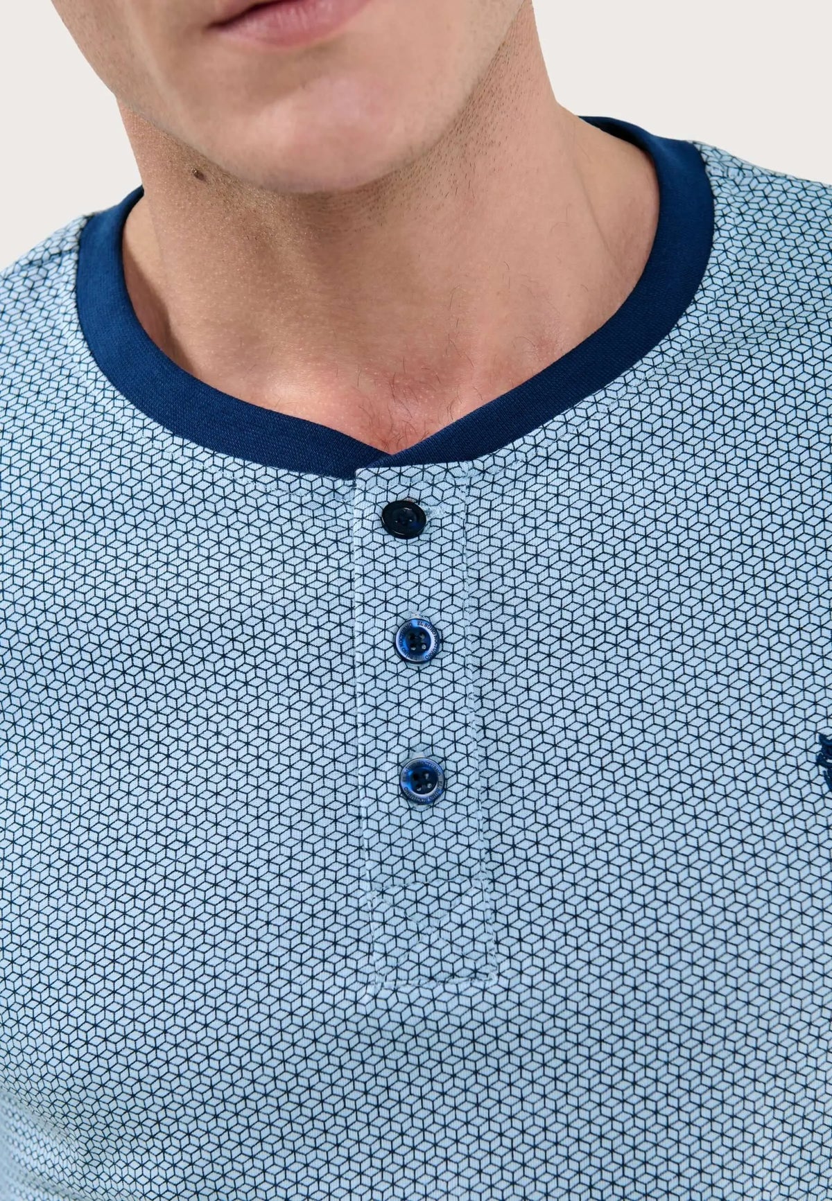 Pijama hombre azul claro estampado geométrico, cuello redondo con tapeta y tres botones oscuros, algodón de punto.