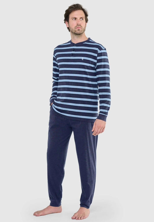 Hombre con pijama largo de rayas azul y marino, camiseta de manga larga con tapeta de botones y pantalón liso azul.