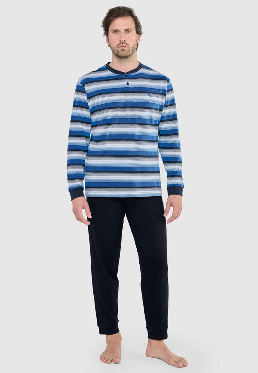 Hombre viste pijama largo de algodón: camiseta a rayas azules y blancas con botones y pantalón recto azul marino liso.