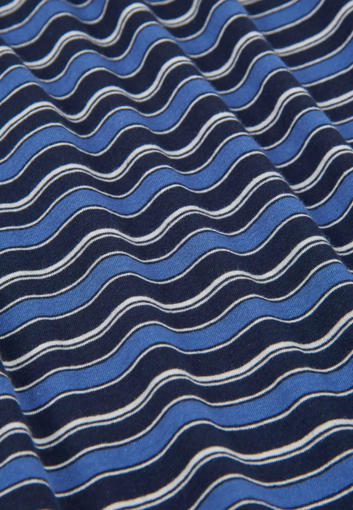Tejido de punto de algodón con estampado de rayas horizontales en tonos azul marino, azul claro y líneas blancas.
