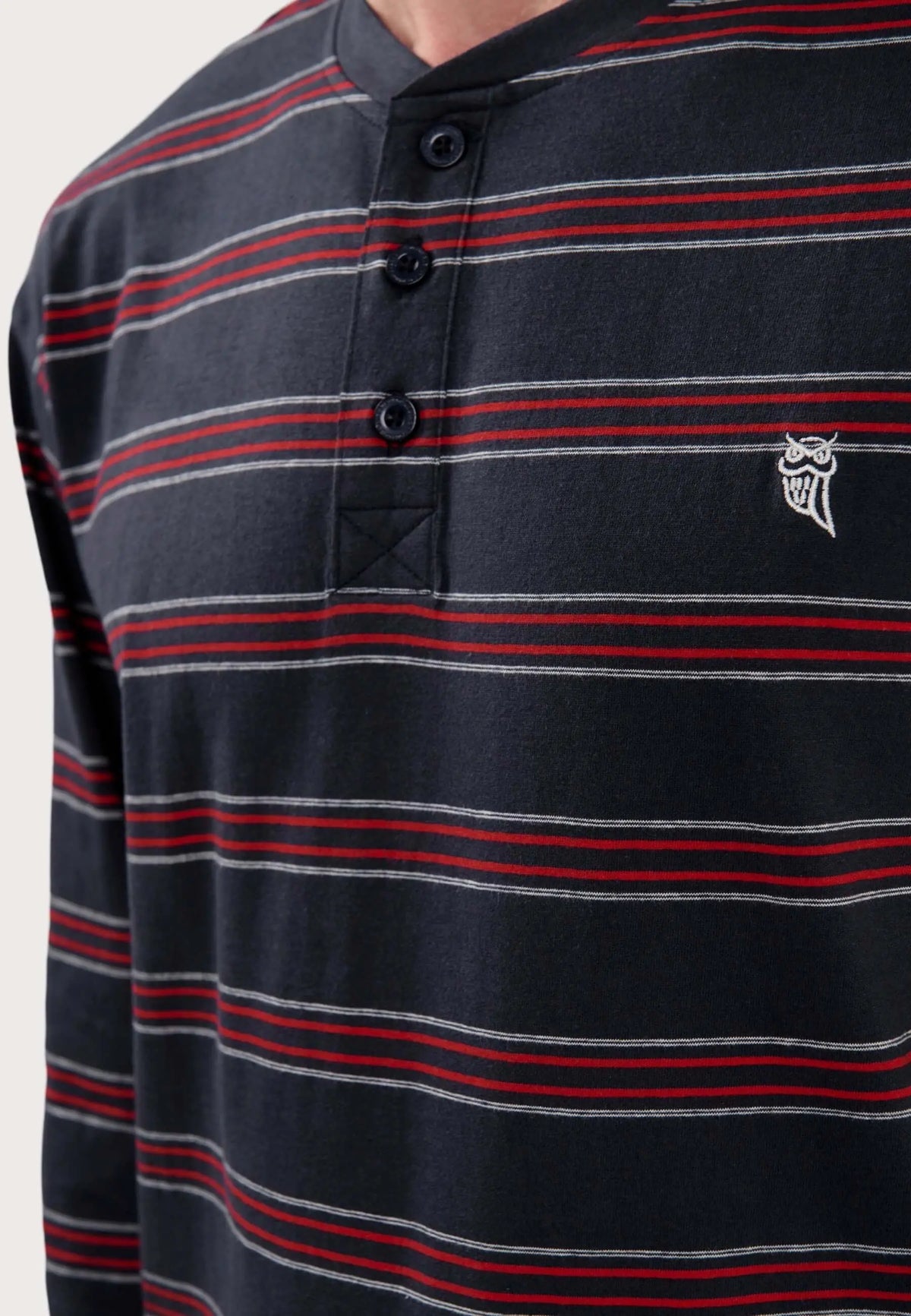 Camiseta pijama hombre, azul marino a rayas rojas y blancas, cuello con tapeta de tres botones y logo de búho bordado.
