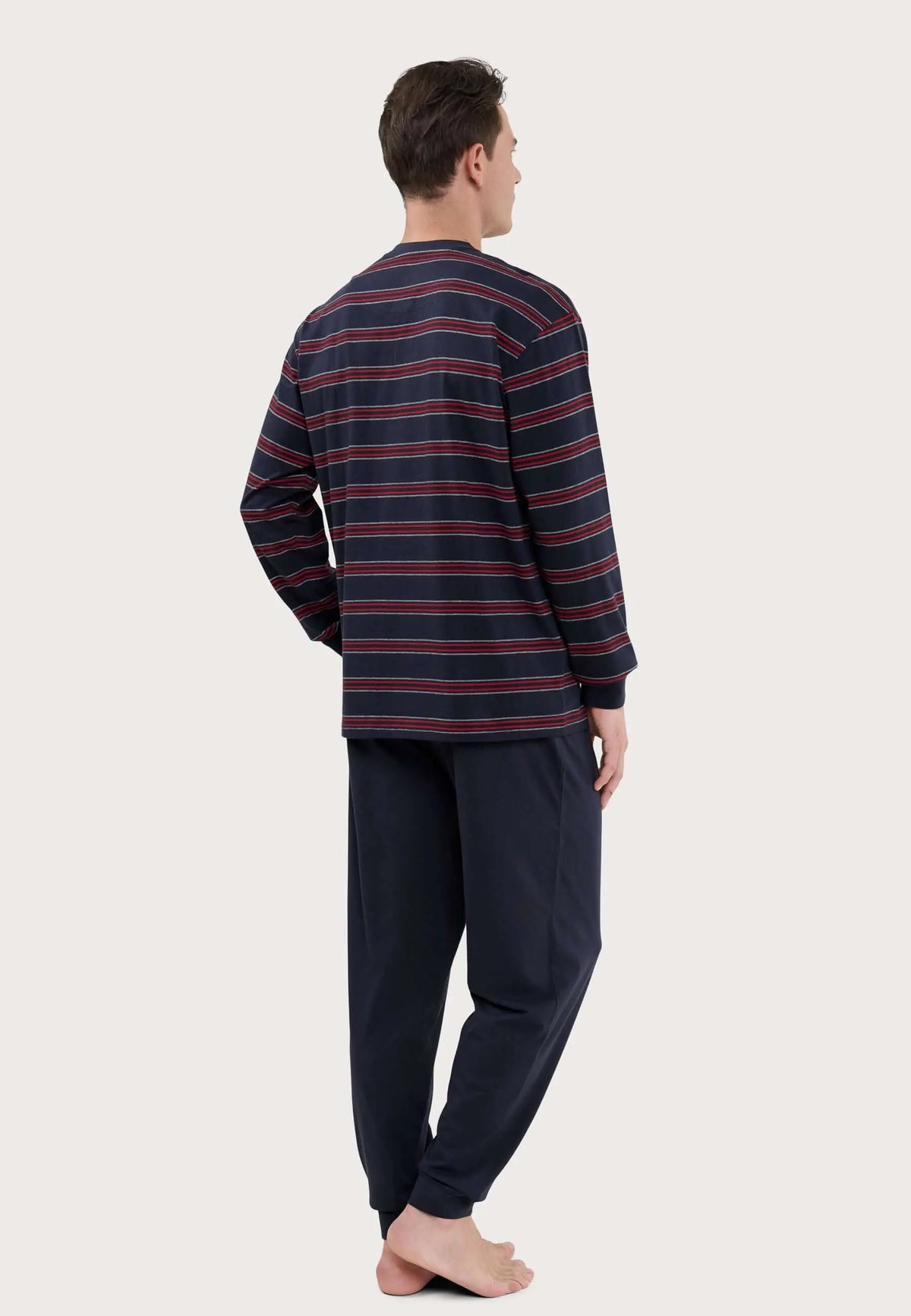 Pijama de hombre con camiseta de rayas horizontales azules y rojas y pantalón largo azul liso en tejido de punto.