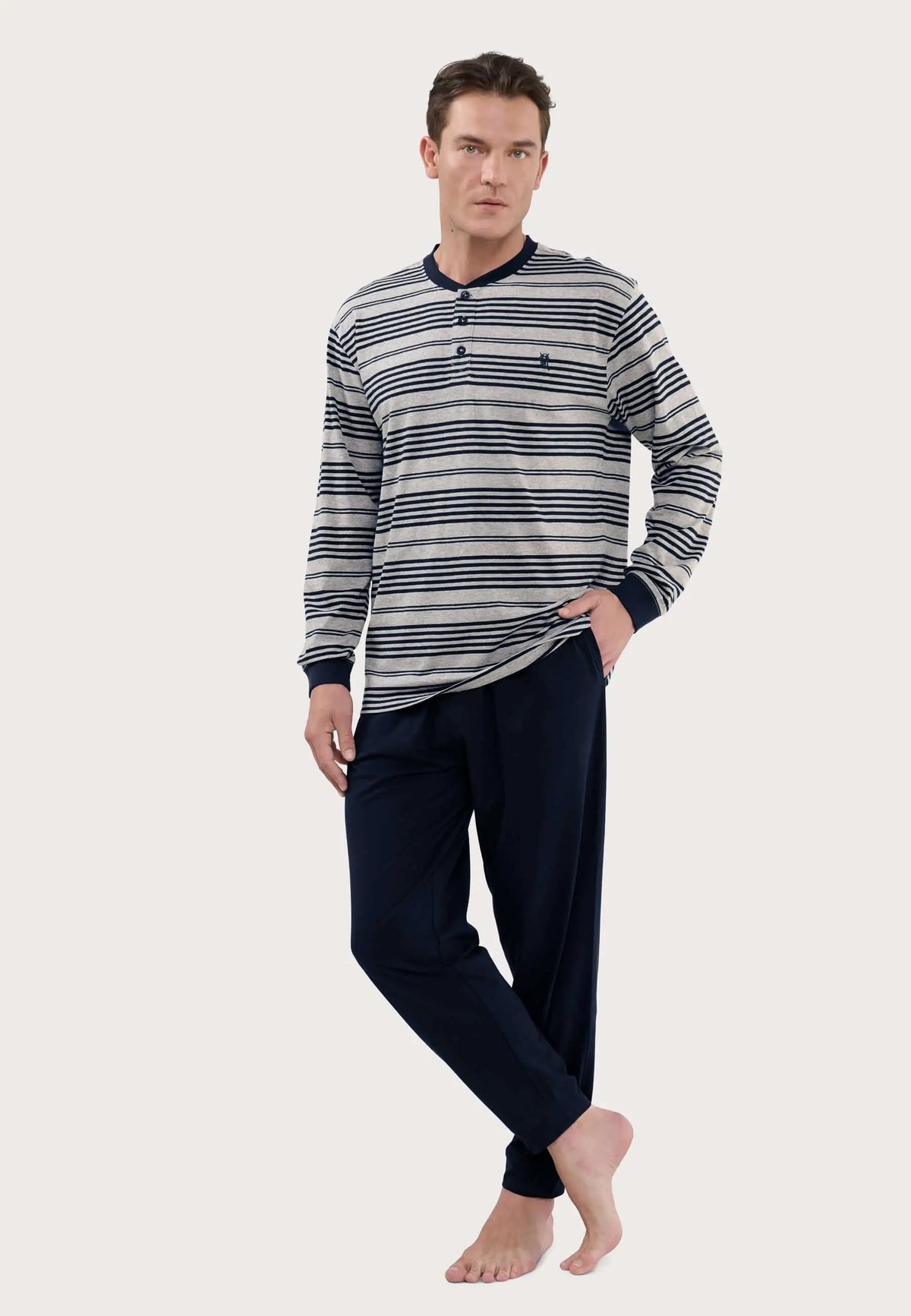 Pijama largo de hombre: camiseta gris a rayas con botones y pantalón azul marino liso, tejido de punto de algodón.