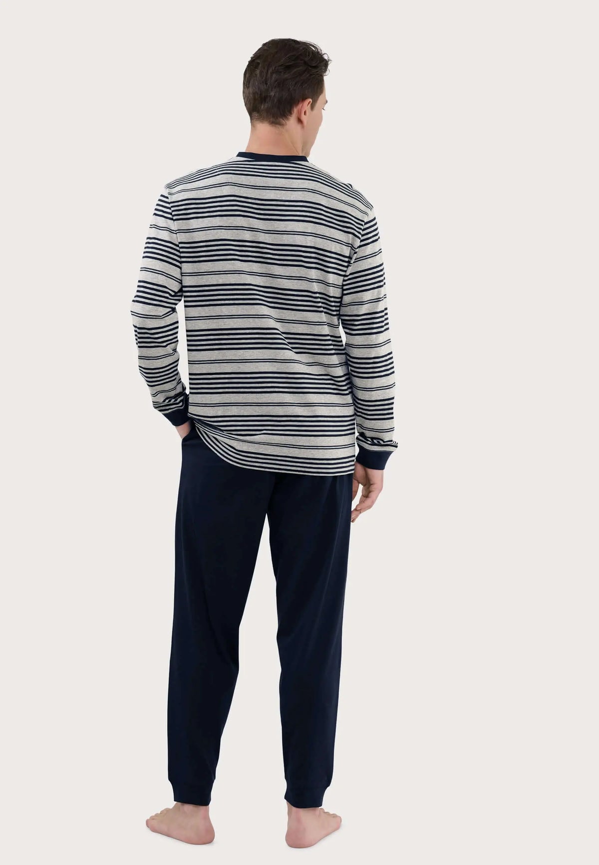 Pijama largo hombre: camiseta gris de rayas horizontales azul marino y pantalón liso azul marino. Vista trasera.
