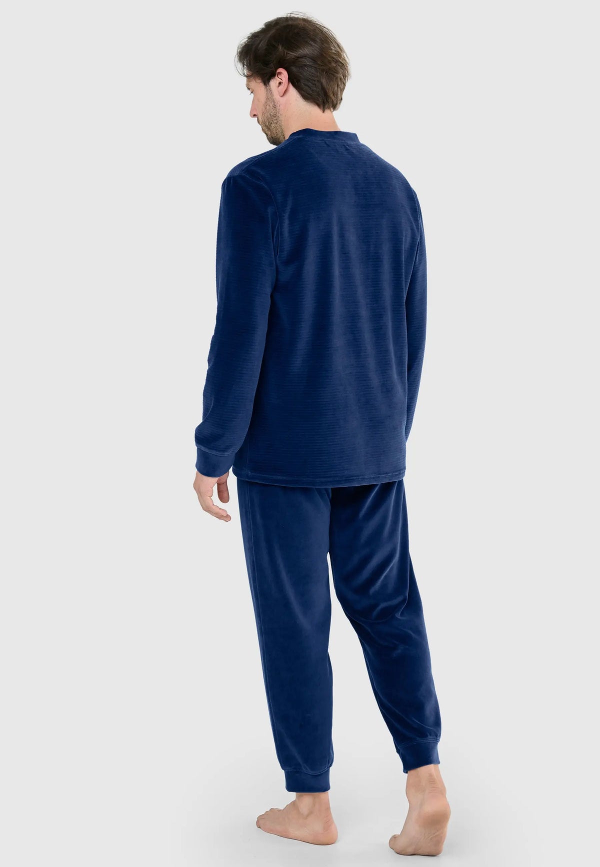 Hombre con pijama de terciopelo azul de manga larga con textura de finas rayas horizontales, espalda vista.