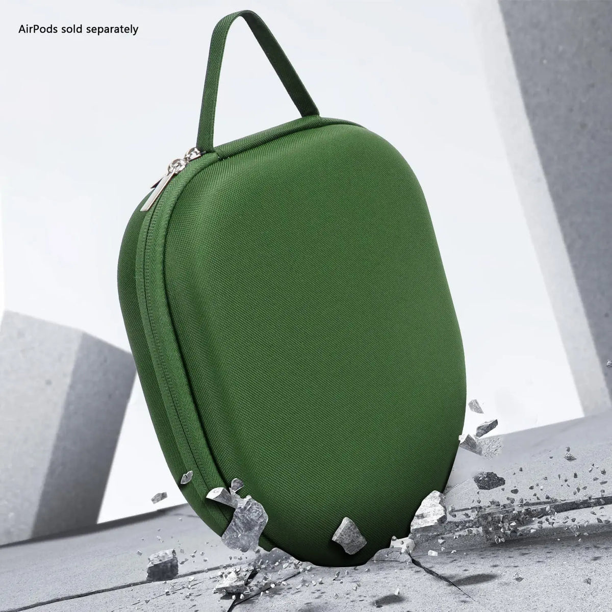 Forest green hard-shell travel case for headphones with a zip closure and carry handle, resting on a cracked surface.