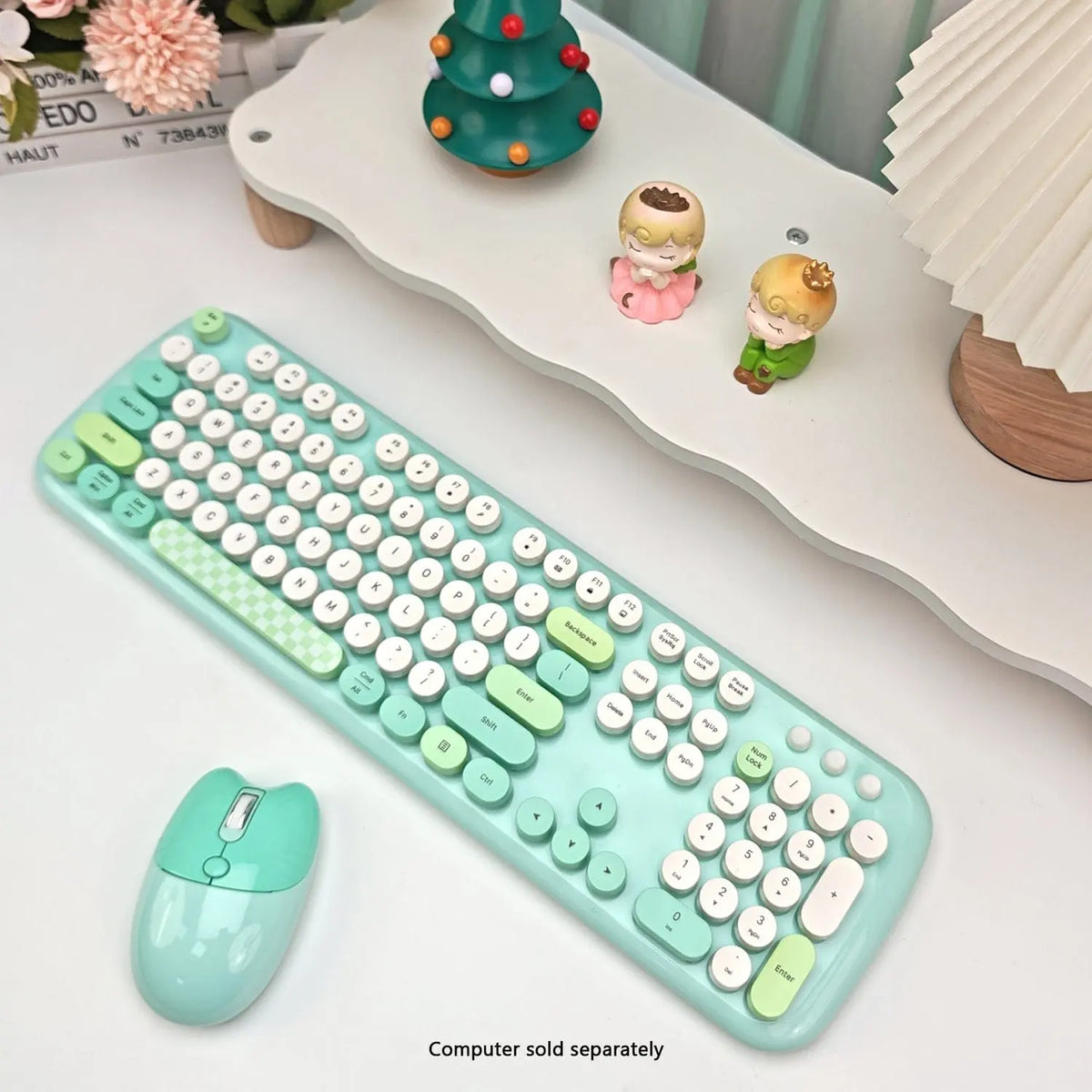 Mint green wireless keyboard and mouse set with 104 round keys, featuring a fun checkered spacebar on a desk setup.