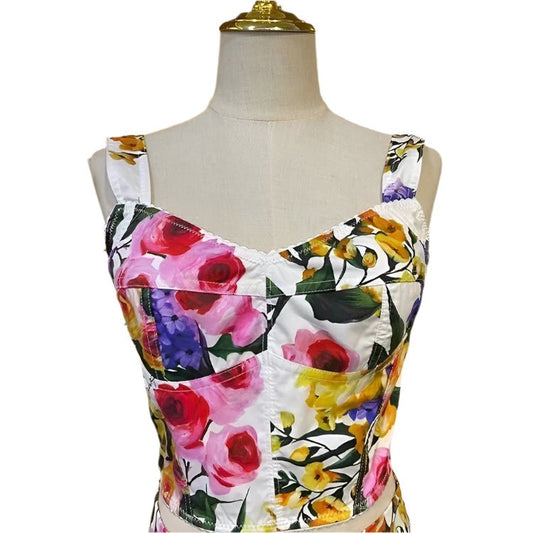 Floral crop top in white satin, featuring vibrant pink, yellow, and purple flowers, perfect for summer outfits.