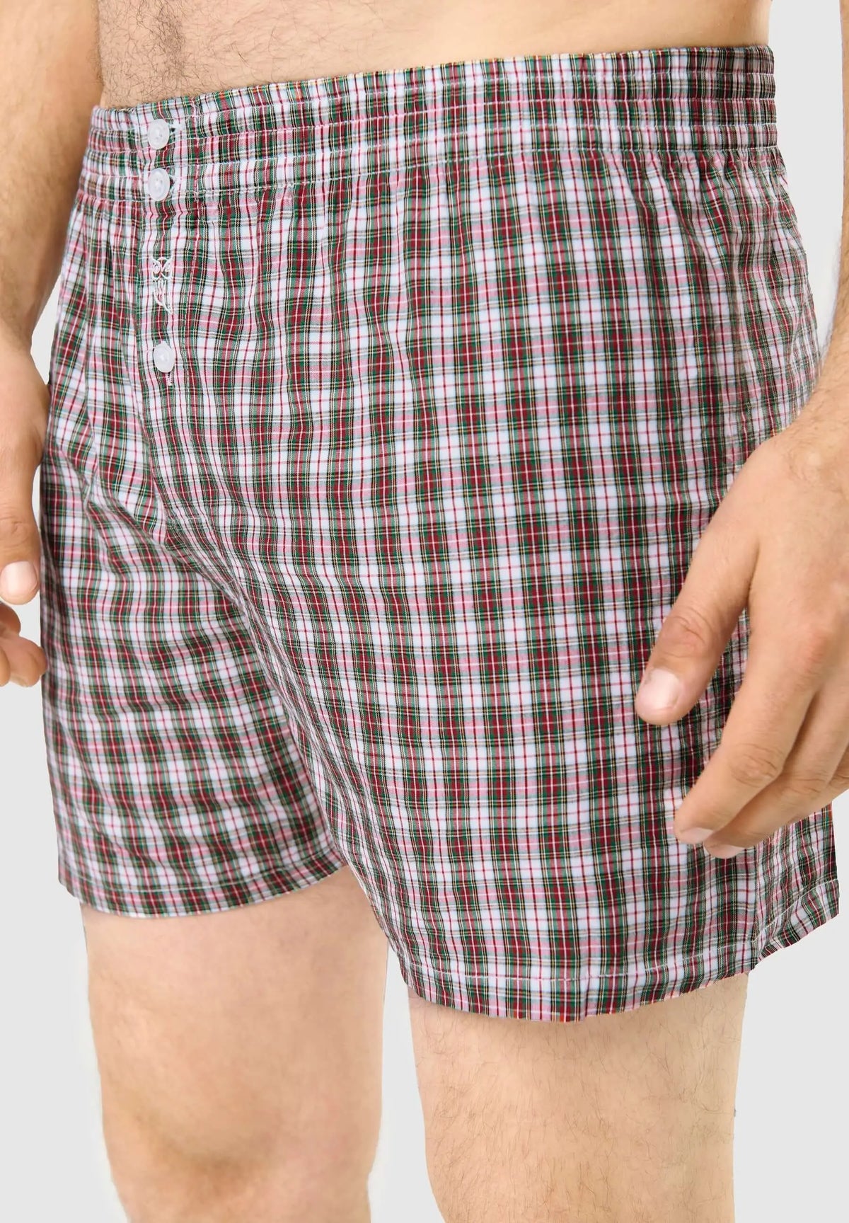 Calzoncillo bóxer de hombre en algodón con estampado de cuadros verdes y rojos, ajuste holgado con botones frontales.