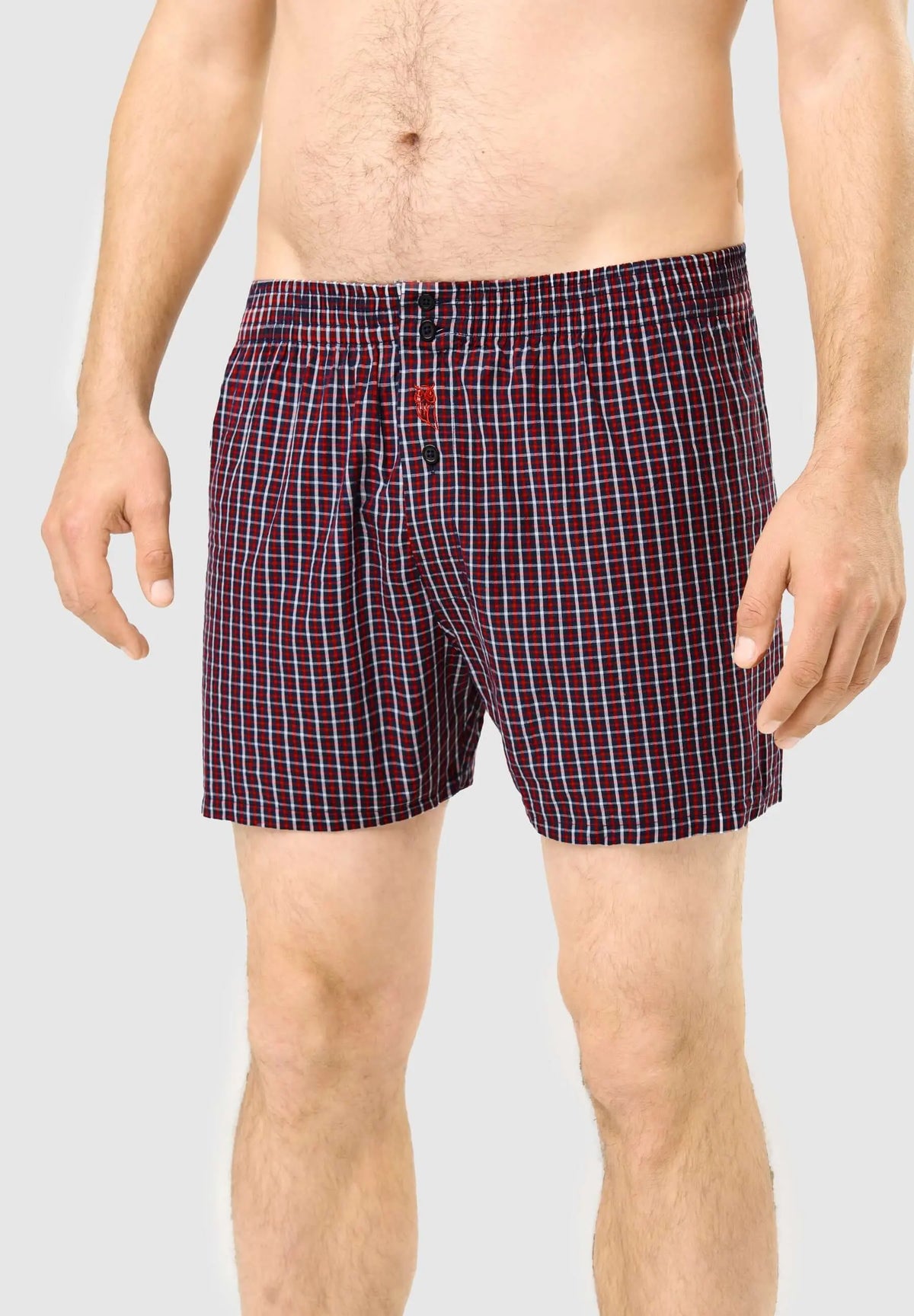 Calzoncillo bóxer de hombre en algodón con estampado de cuadros rojos y azules, ajuste holgado y cierre de botones.