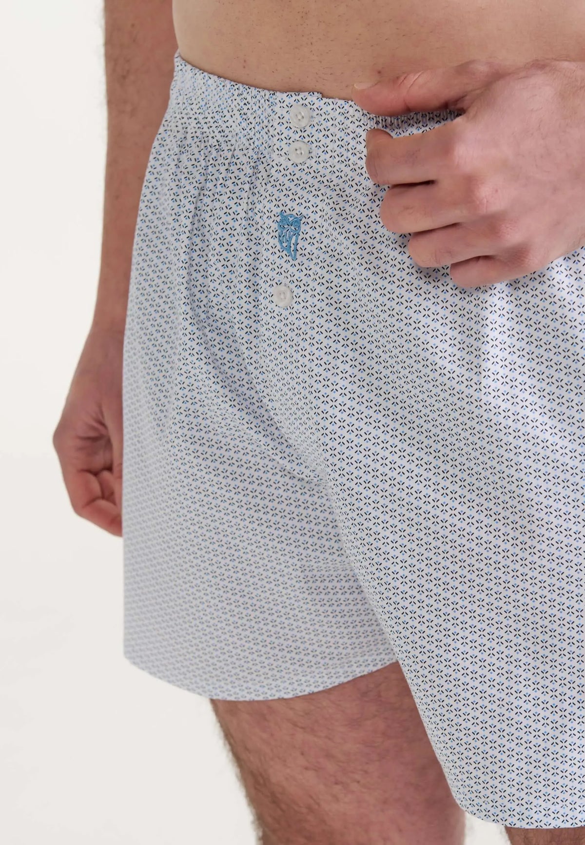 Bóxer de hombre estilo holgado en algodón blanco con estampado geométrico celeste y cierre de botones.