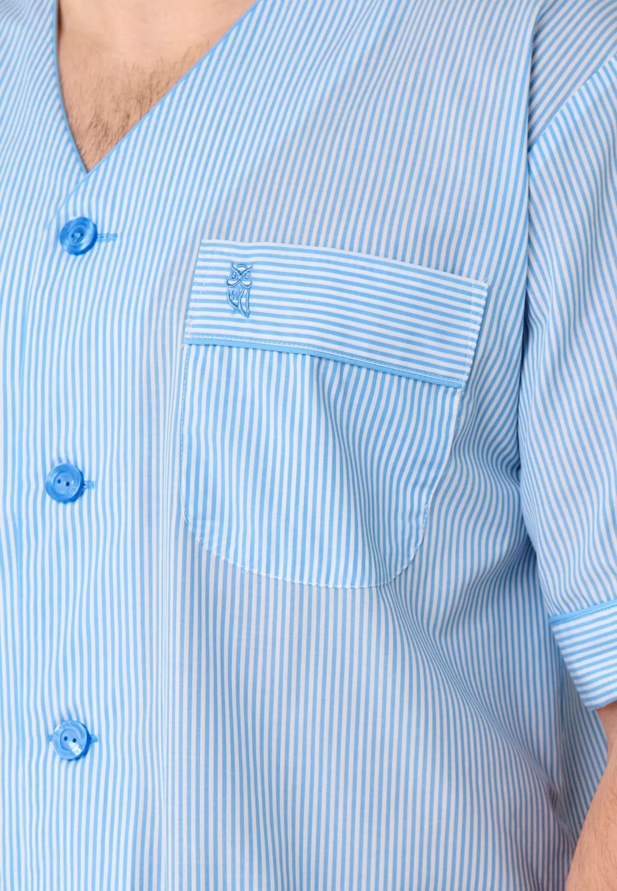 Pijama de hombre a rayas azul y blanco con cuello en pico, botones azules, bolsillo con logo de búho bordado.