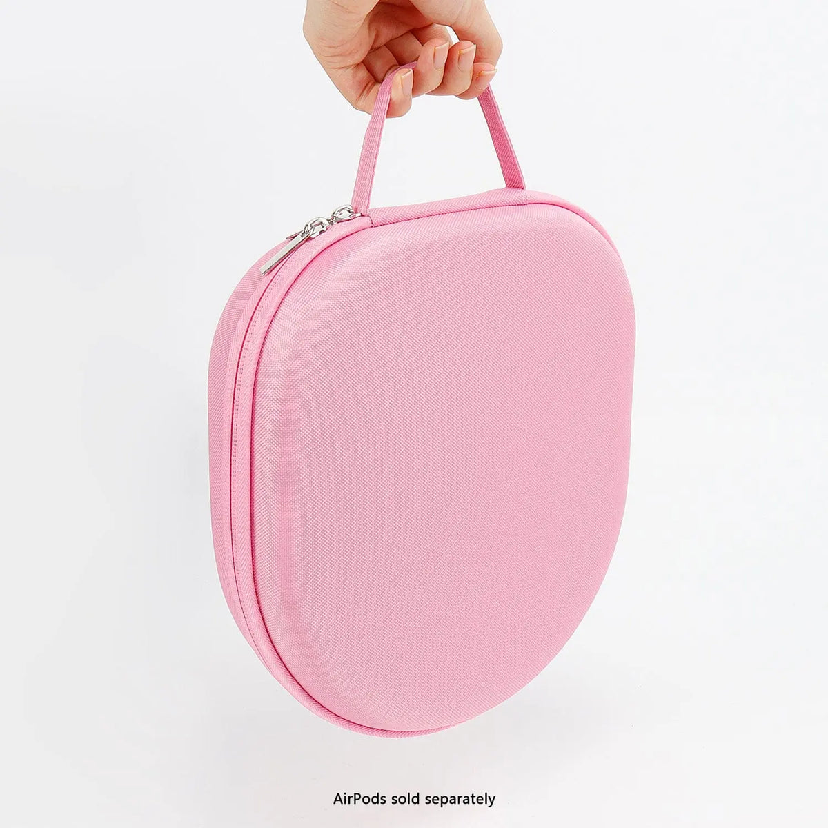A hand holds a pink, hard-shell travel case for AirPods Max with a matching carry handle and a zip closure.