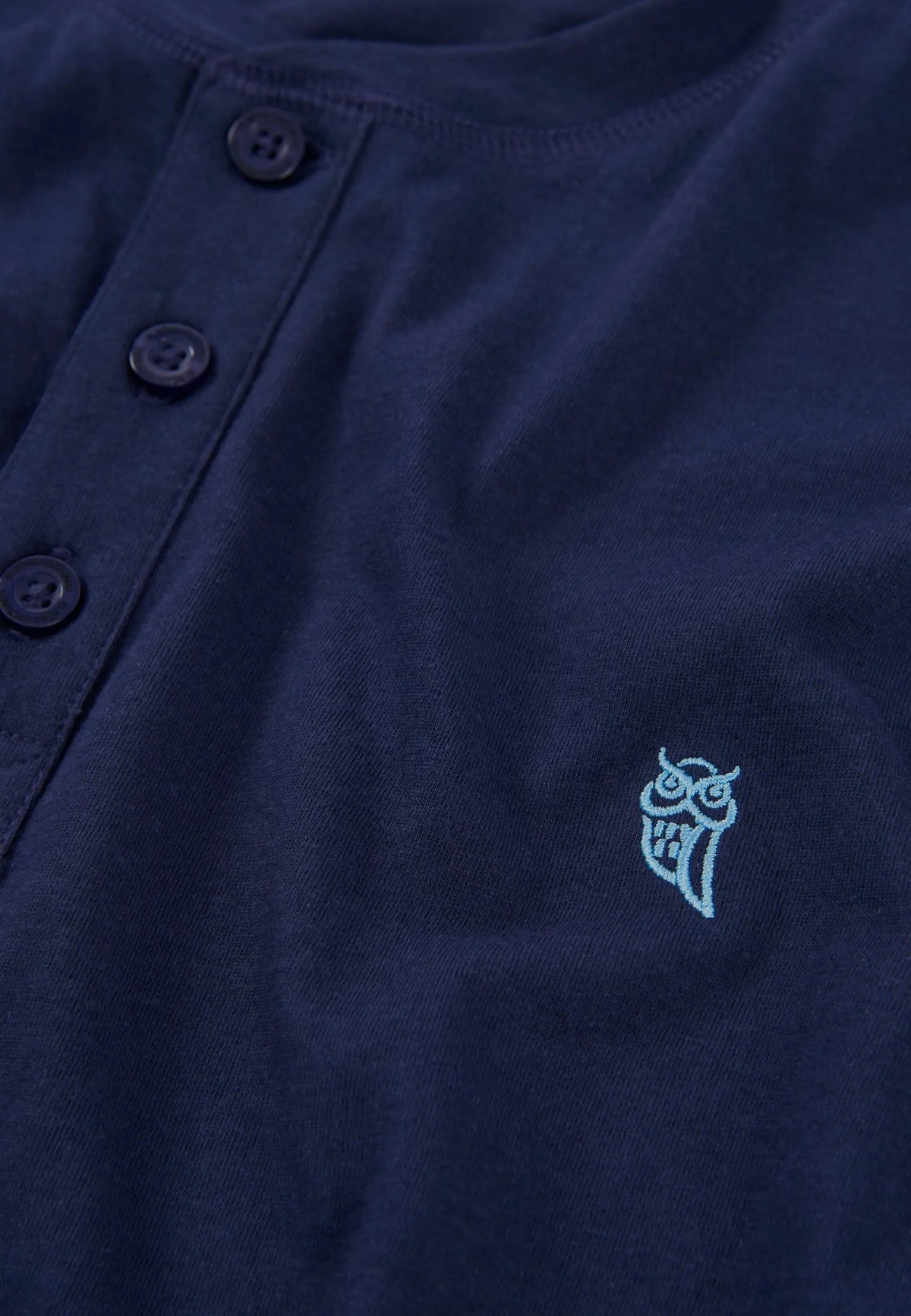 Camiseta de botones color navy con bordado de búho en tono aqua, de algodón suave y estilo casual.