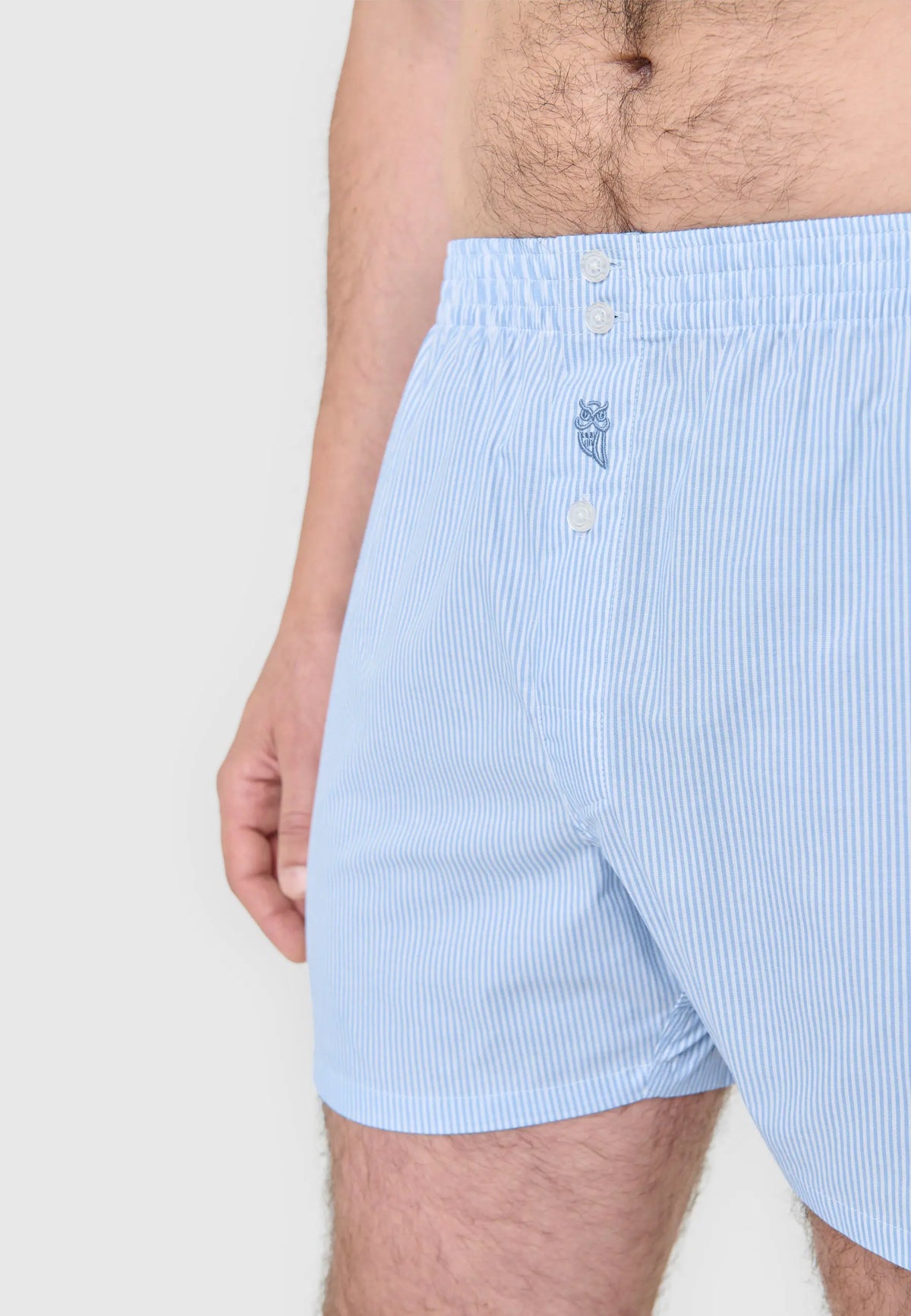 Boxer de hombre azul claro a rayas, fabricado en algodón suave, con diseño clásico y botón frontal.
