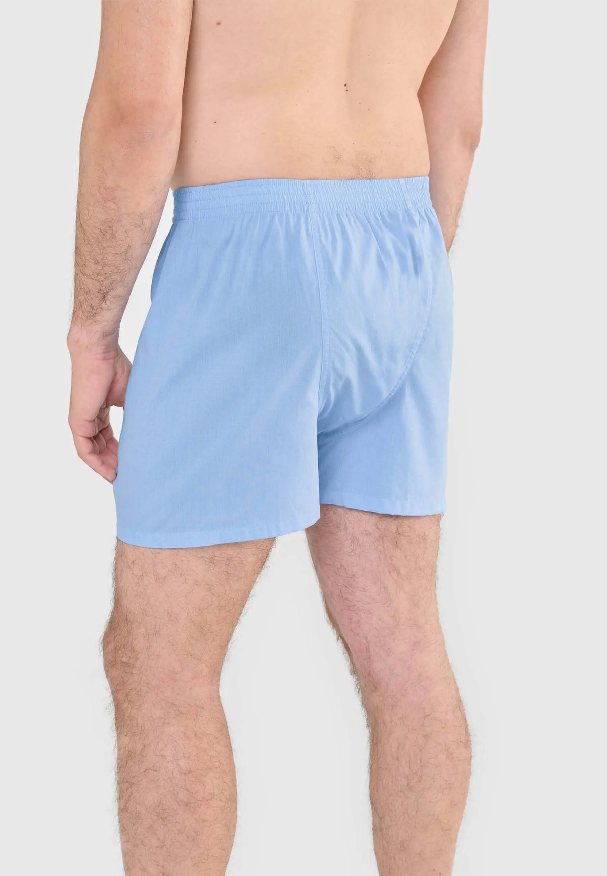 Calzoncillo bóxer para hombre de algodón liso en color celeste con ajuste holgado y cintura elástica.