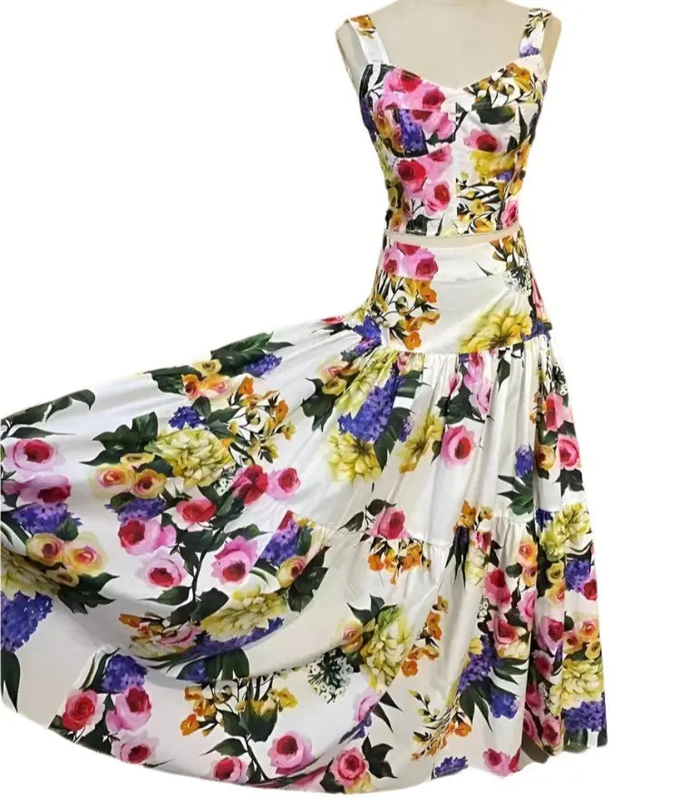 White cotton two-piece set featuring a bustier crop top and a tiered maxi skirt with a vibrant multi-floral print.