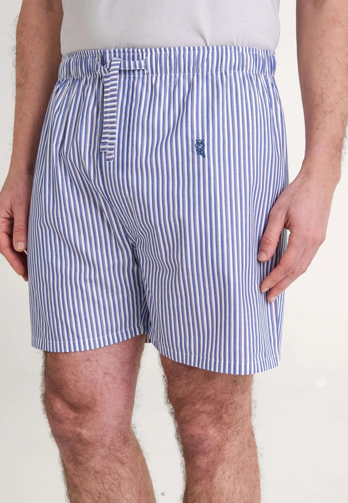 Pantalón corto de pijama para hombre en popelín de algodón, estampado de rayas verticales azul y blanco con ajuste cómodo.