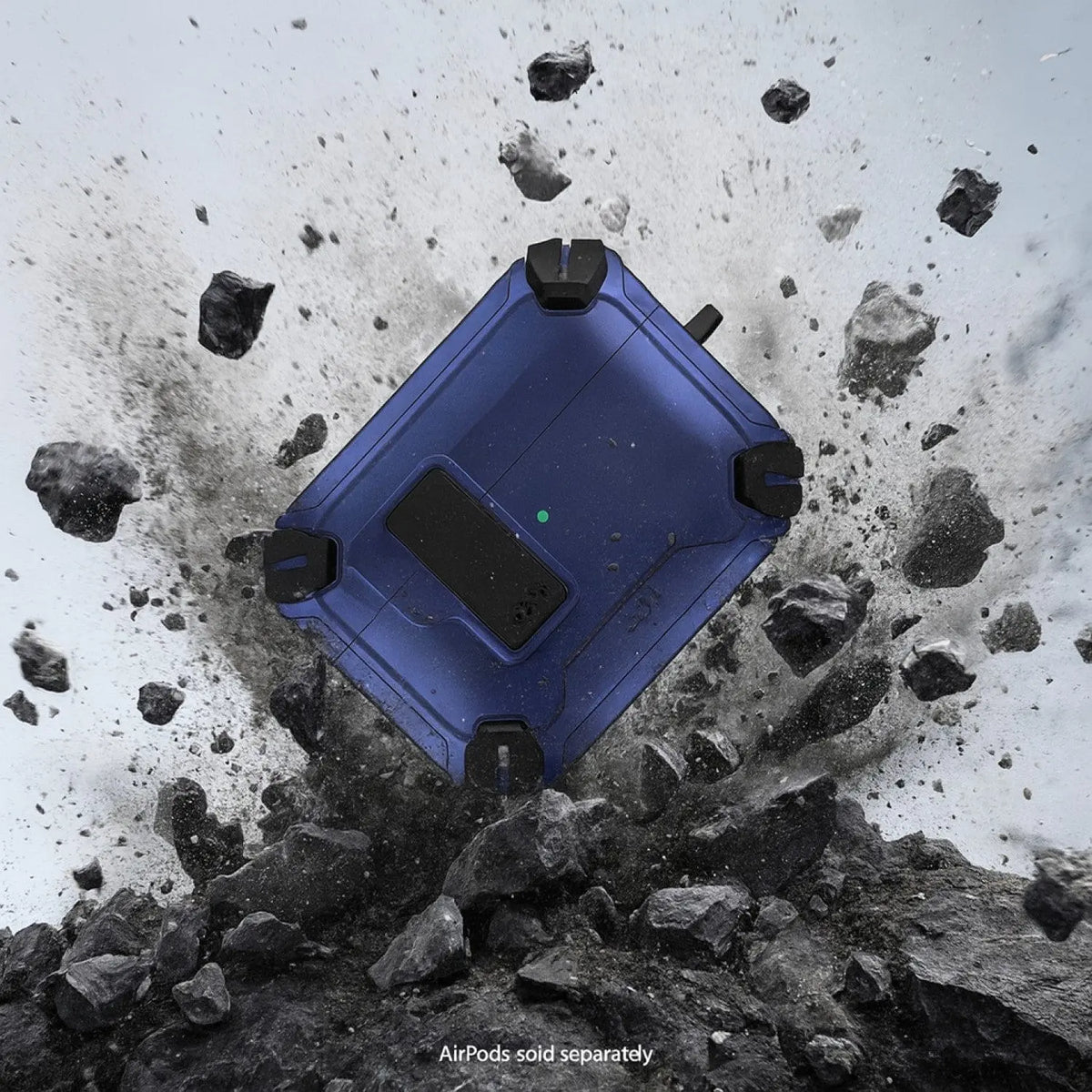 Rugged blue AirPods Pro case with black corner bumpers and secure lock, surrounded by flying rocks and dust.