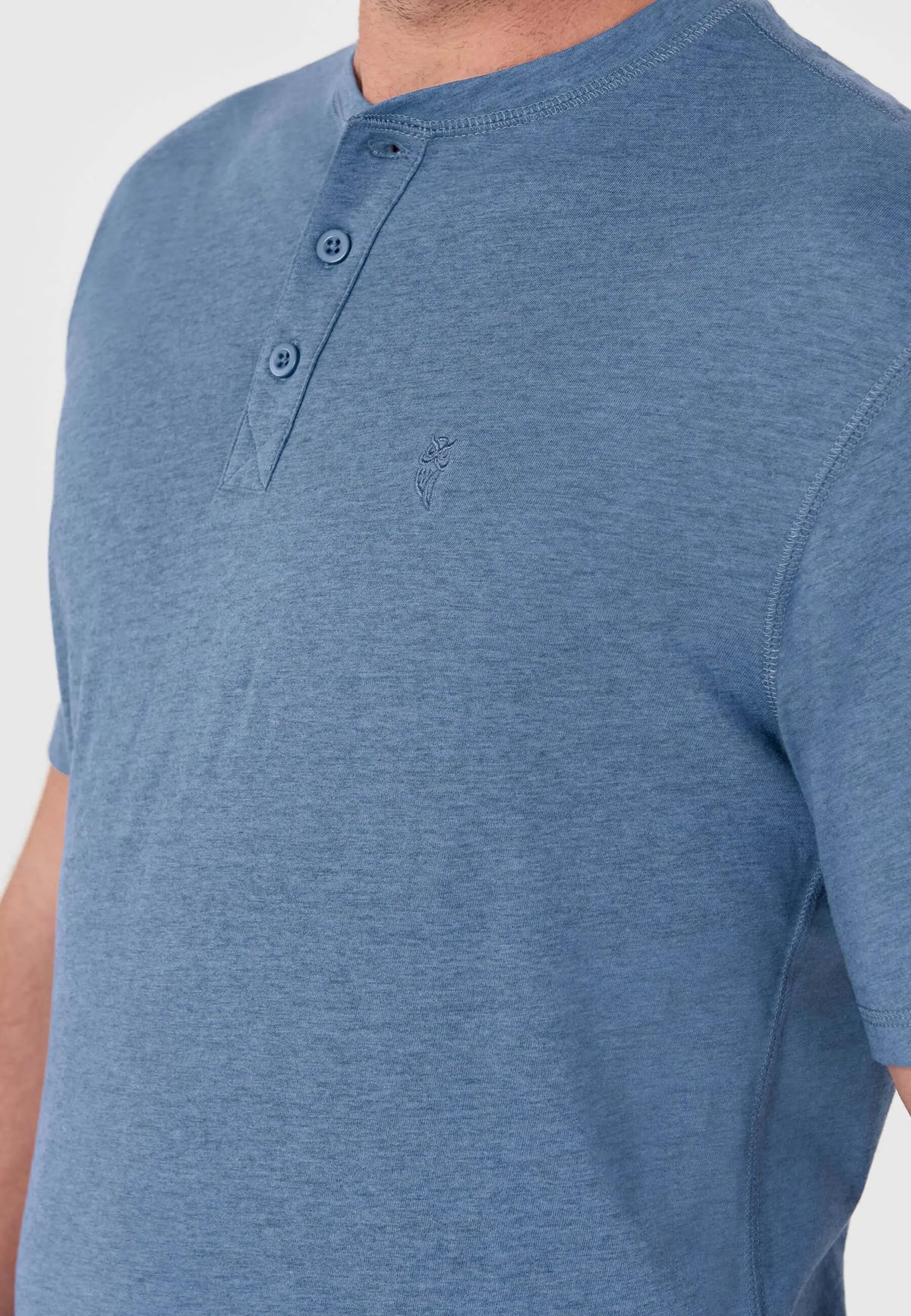Camiseta de pijama azul jaspeado, cuello panadero con dos botones y logo bordado en el pecho. Estilo casual de verano.