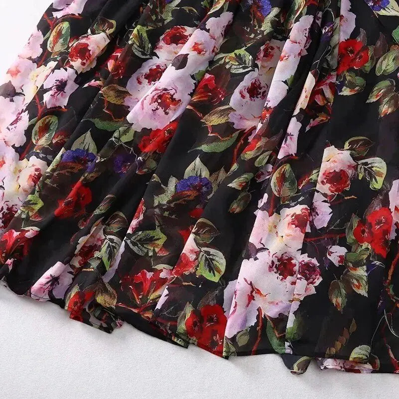 Black floral maxi dress with vibrant red and pink roses, crafted from lightweight chiffon fabric. Perfect for summer outings.