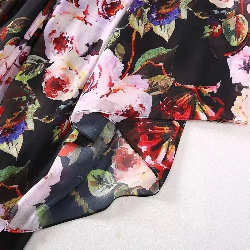 Black floral chiffon fabric with vibrant pink and red roses, perfect for dresses and lightweight garments.