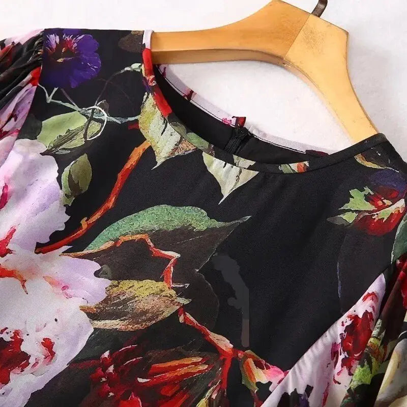 Black floral blouse with vibrant red and purple flowers, featuring a round neck and soft fabric, perfect for casual wear.