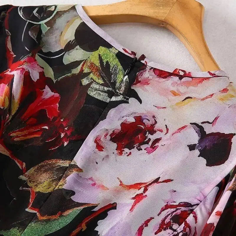 Floral print blouse in vibrant red, purple, and black, featuring a lightweight fabric and elegant round neckline.