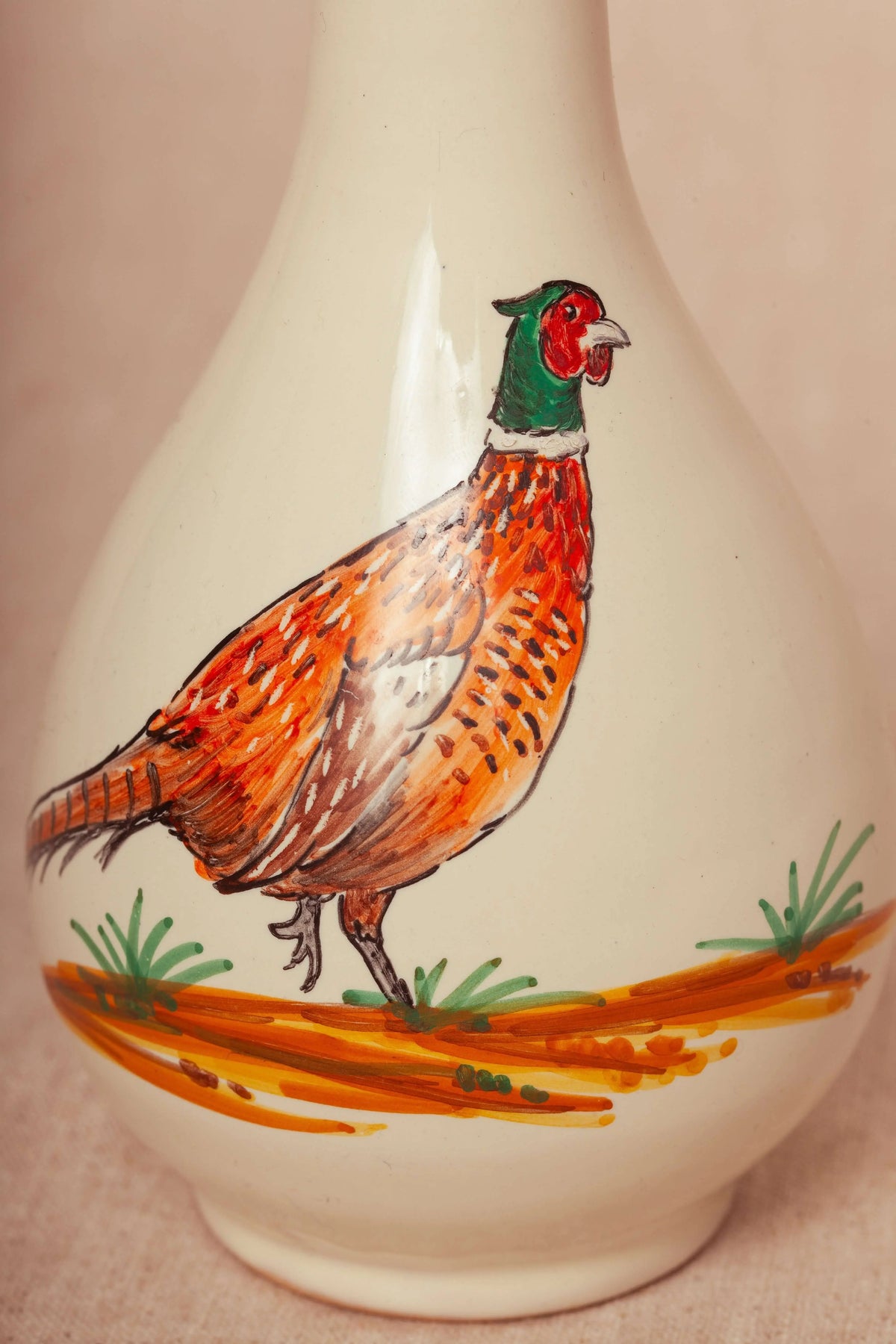 Cream-colored ceramic oil cruet featuring a hand-painted, vibrant orange and green pheasant design.