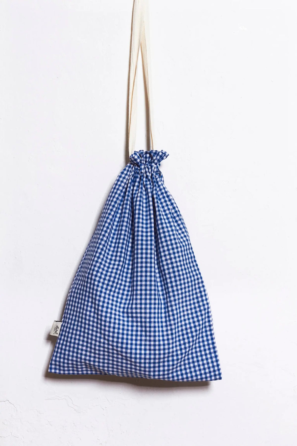 Panera de tela con estampado de cuadros vichy azul y blanco, estilo rústico, con cierre de cordón ajustable.