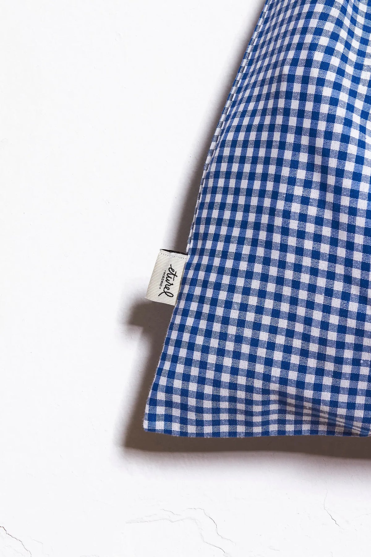 Panera de tela con estampado de cuadros vichy en azul y blanco sobre fondo blanco. Estilo rústico y textil.