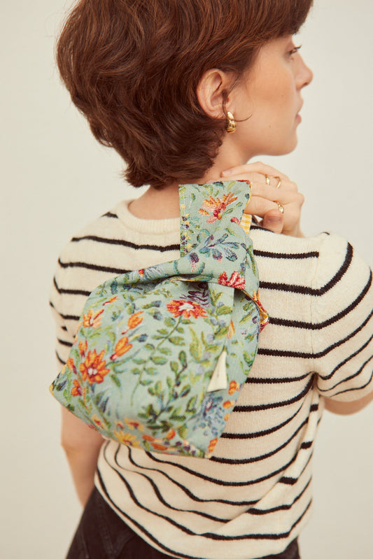 Bolso de tela verde con bordado floral colorido, estilo moderno, ideal para uso diario.
