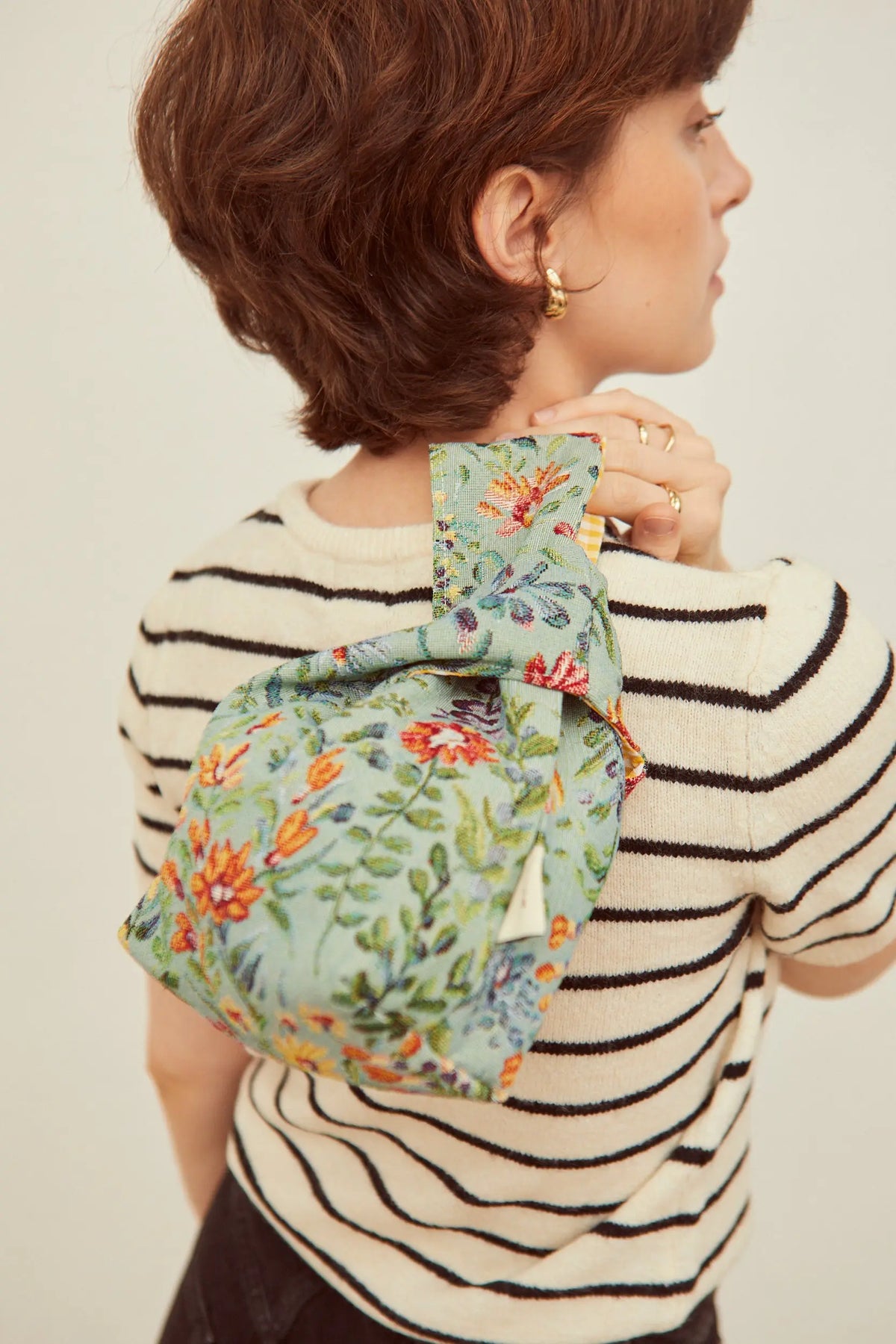 Bolso de tela verde con bordado floral colorido, estilo moderno, ideal para uso diario.