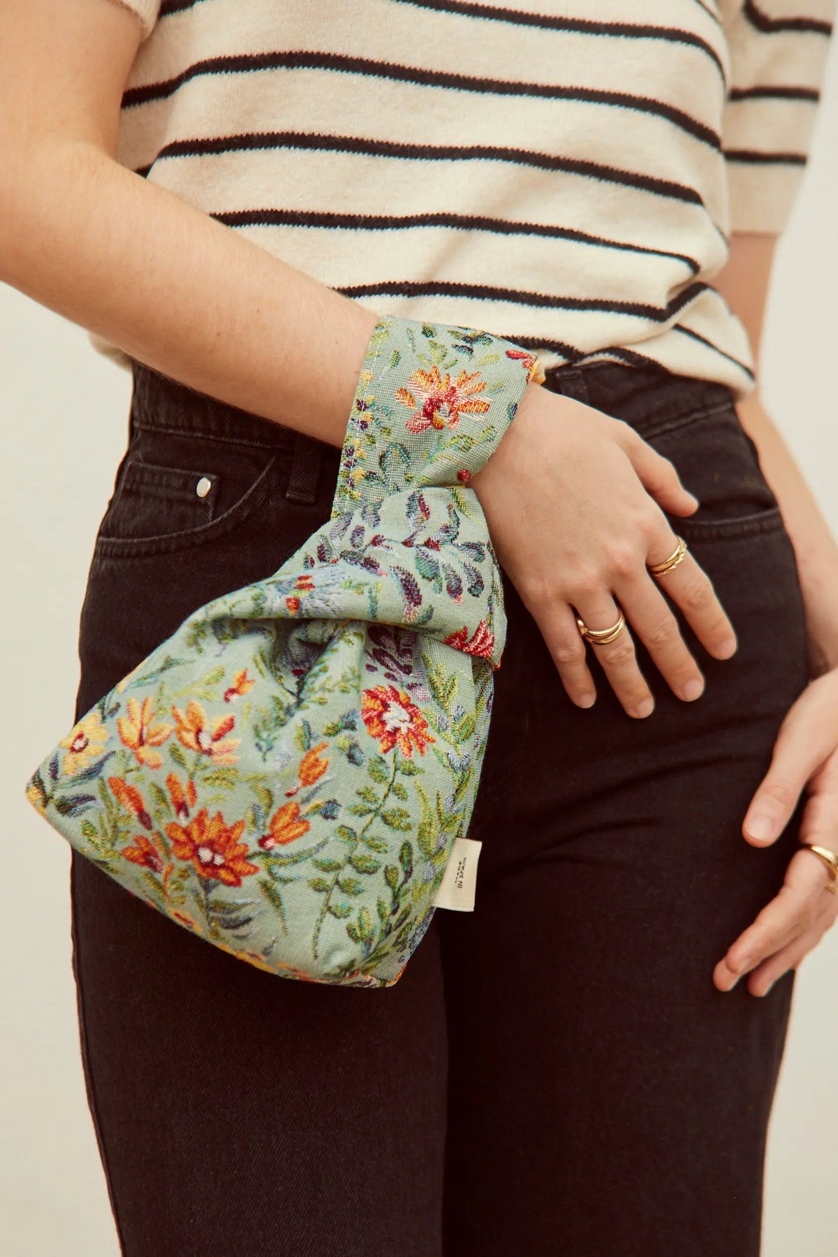 Bolso de mano verde con bordado floral en tonos cálidos, estilo bohemio, tejido de algodón.