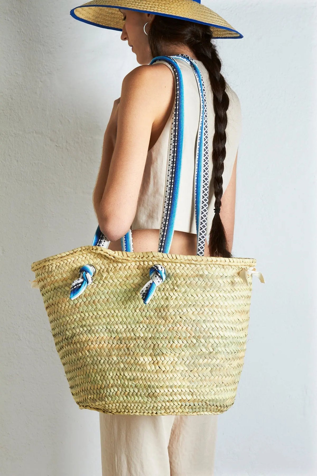 Bolso de playa de paja trenzada, color beige con asas de rayas azules y blancas, estilo bohemio.
