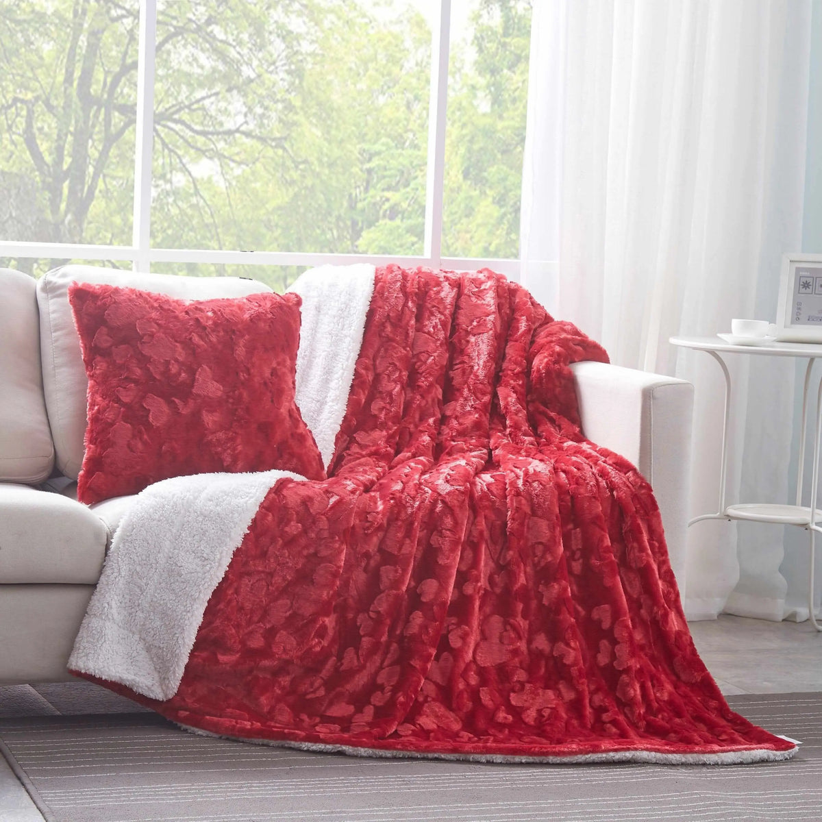 Candy apple red square faux fur pillow with a textured heart pattern, featuring a soft white sherpa reverse side.