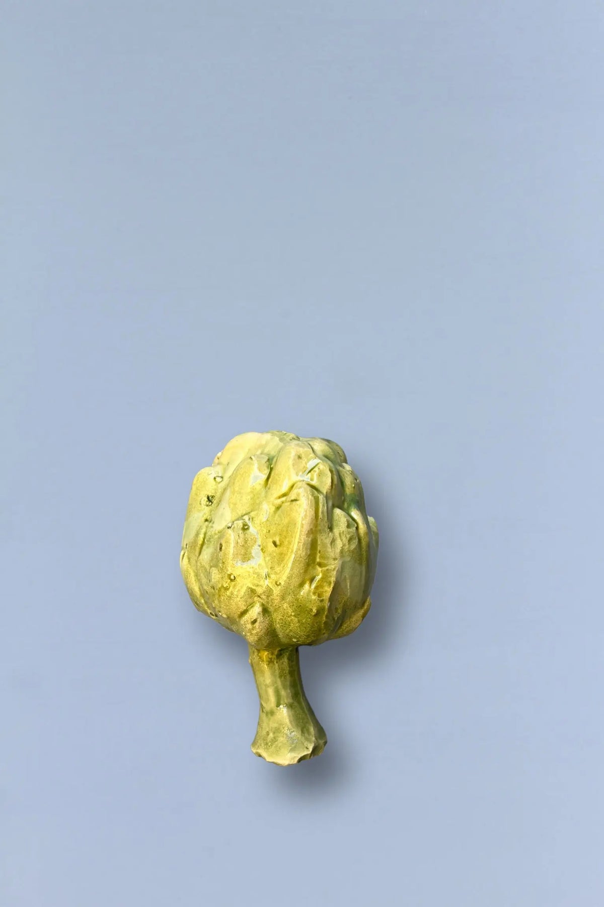 Alcachofa fresca verde sobre fondo gris, ideal para ensaladas y platos saludables.