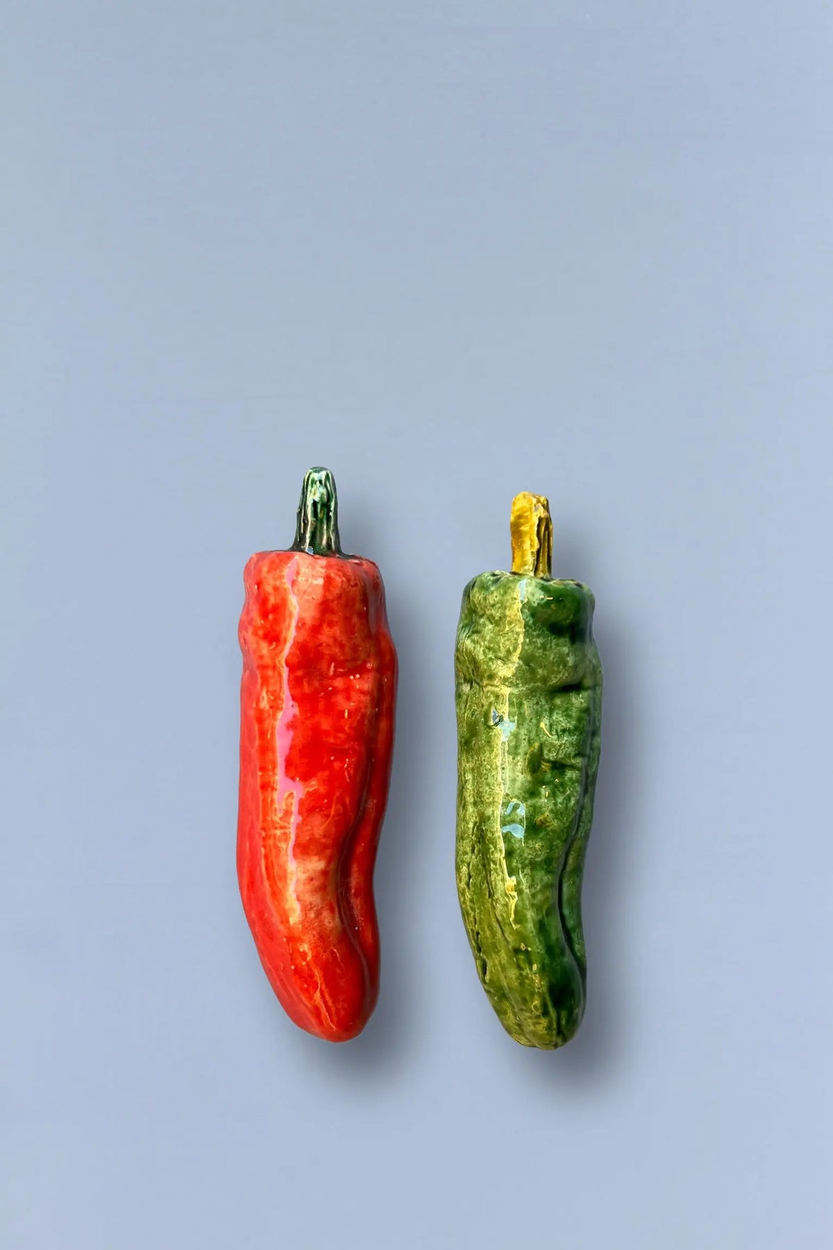 Pimientos de cerámica roja y verde, con detalles en dorado, estilo moderno y decorativo para cocina.