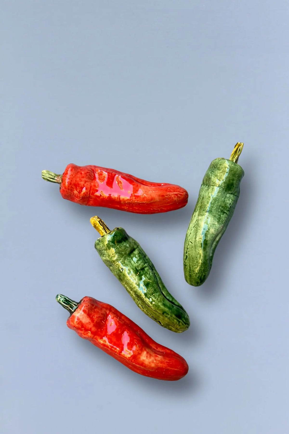 Chiles de cerámica roja y verde brillante, decorativos, perfectos para cocina o decoración rústica.