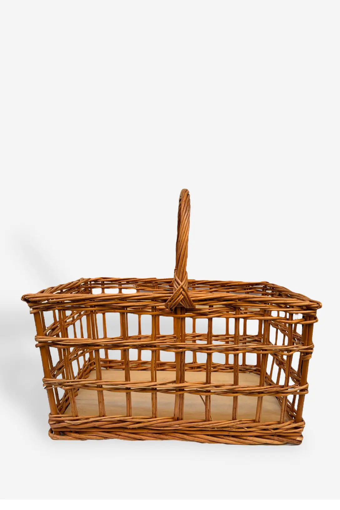 Cesta de picnic rectangular de mimbre natural con diseño calado, estructura abierta y asa central, tono madera cálido.