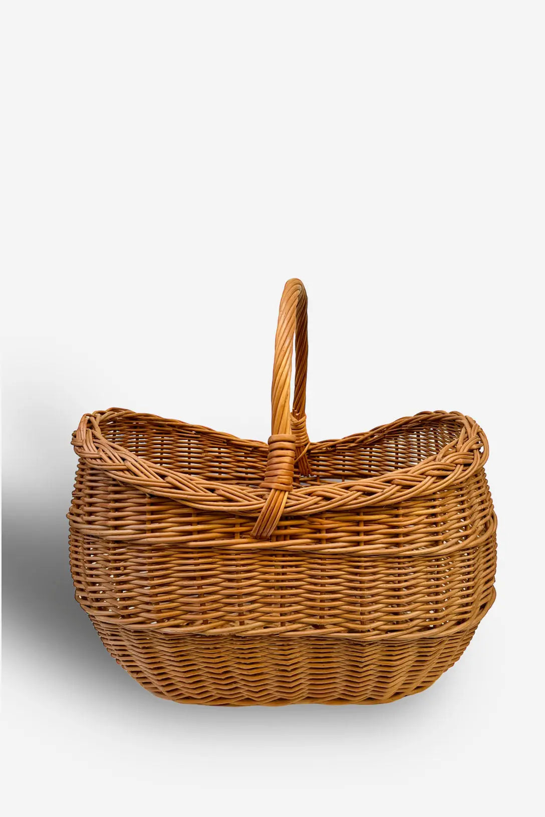 Natural brown wicker basket with a rounded rectangular shape, braided rim, and a sturdy vertical top handle.