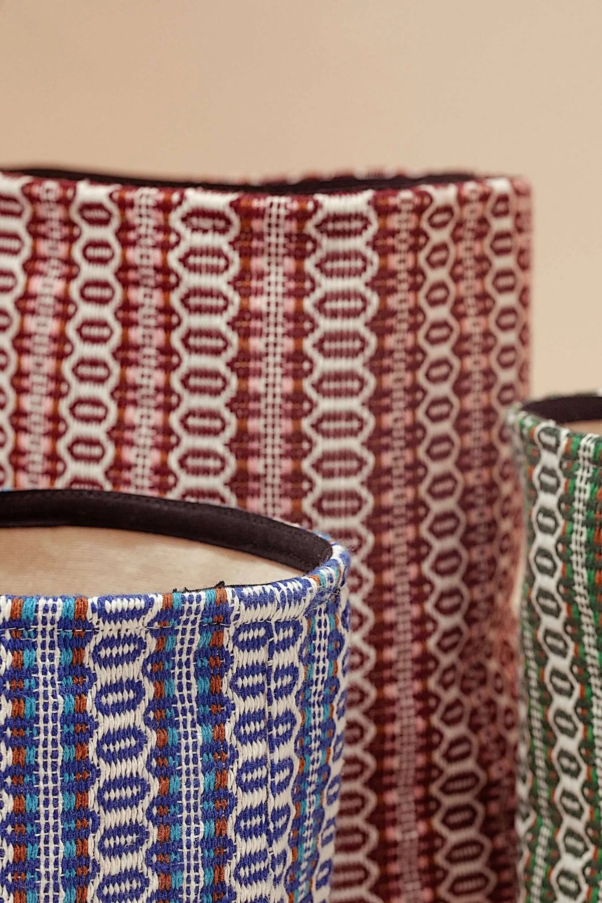 Cestos de tela con estampado ojo de perdiz en tonos azul, granate y verde, con estilo retro y textura tejida.