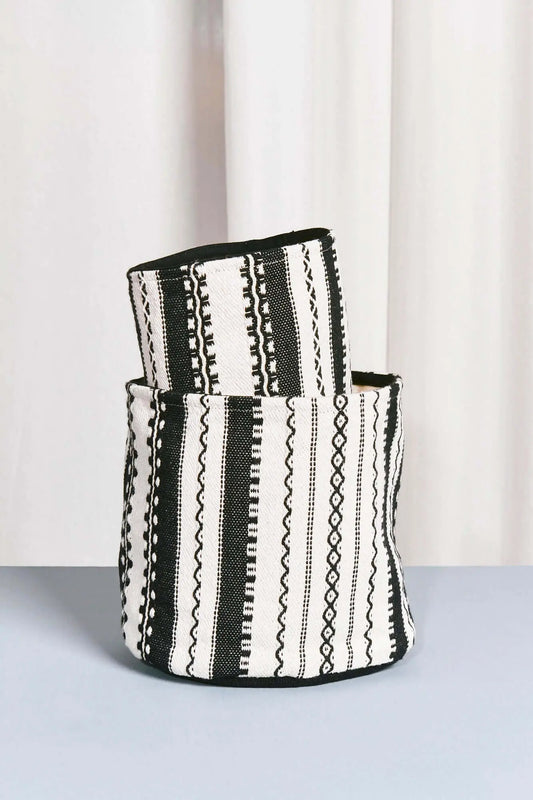 Two cylindrical fabric storage baskets with a black and white striped, geometric Alpujarra-style woven pattern.