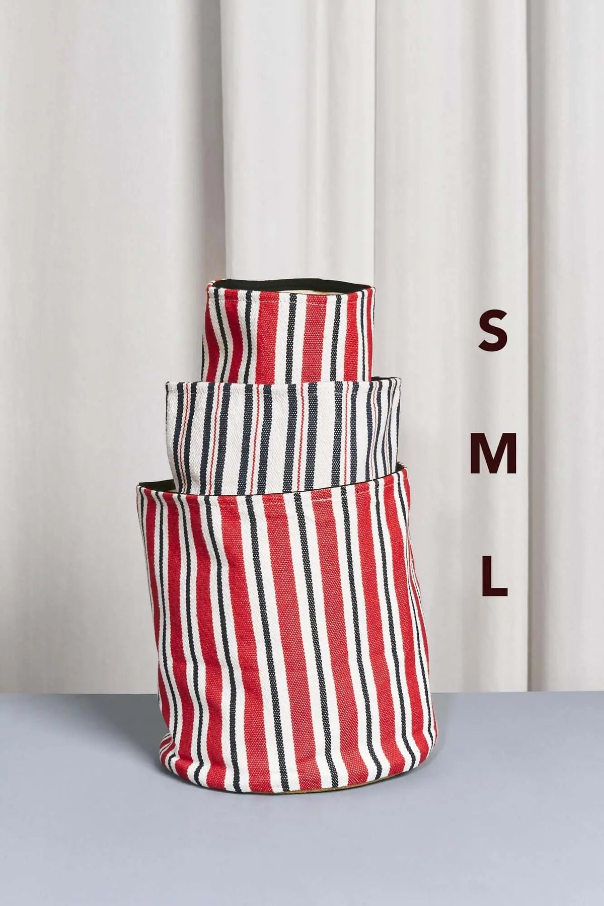 Three cylindrical canvas baskets in varying sizes, featuring red, navy blue, and white vertical stripes.