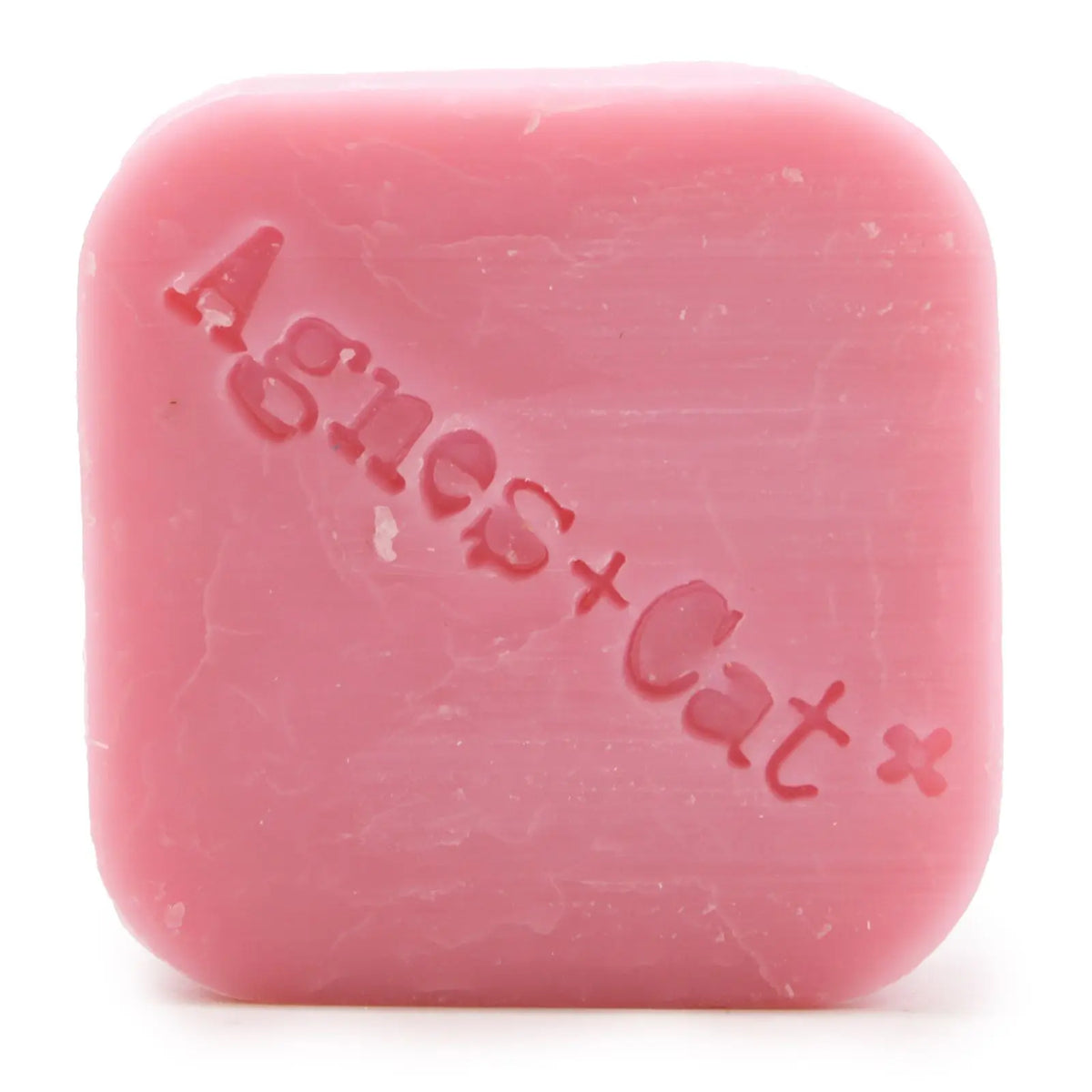 Pastilla de champú sólido rosa, forma cuadrada con bordes redondeados y el logo "Agnes+Cat" grabado en el centro.
