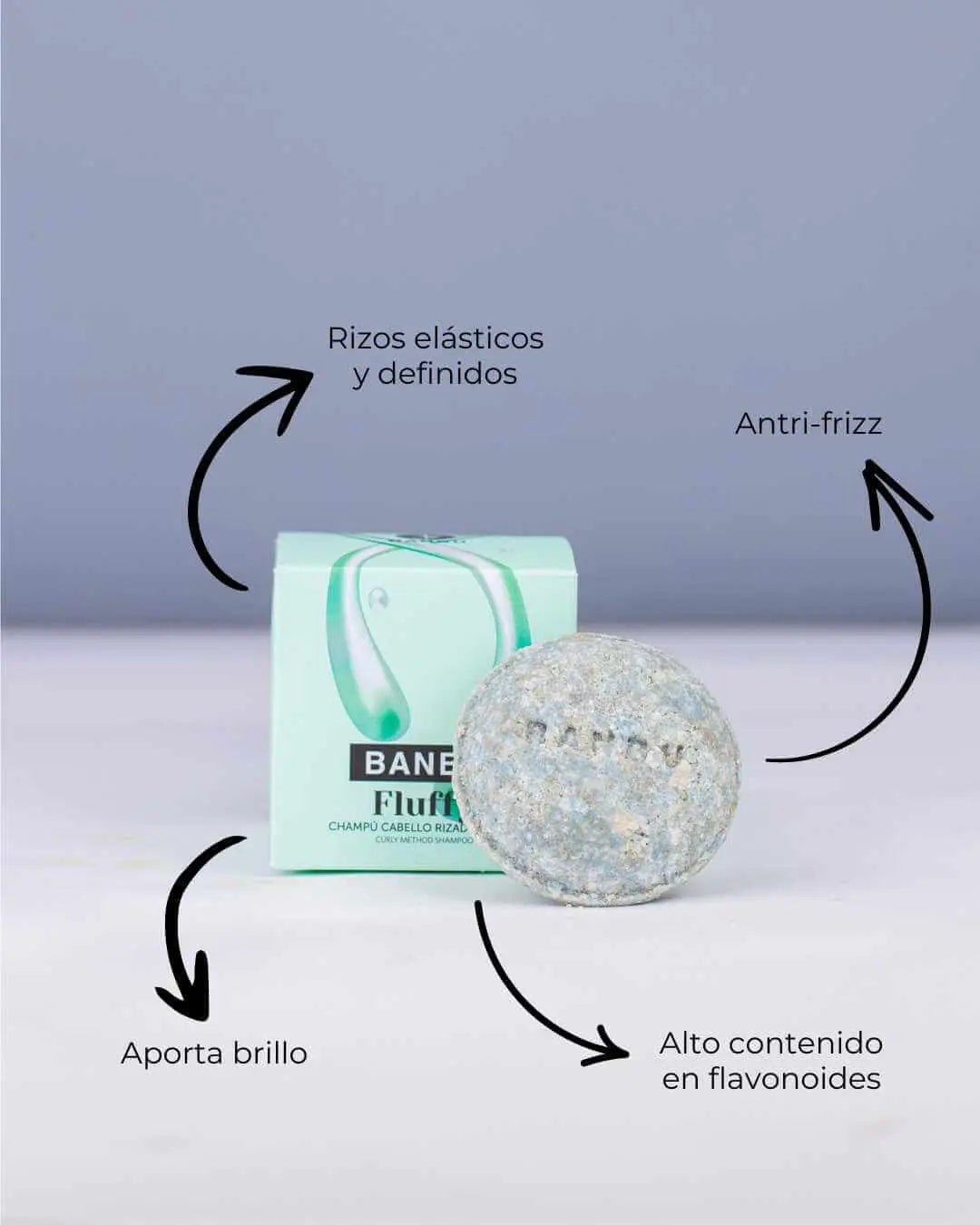 Champú sólido Banbu Fluffy para rizos junto a su caja verde claro. Flechas indican sus beneficios contra el encrespado.