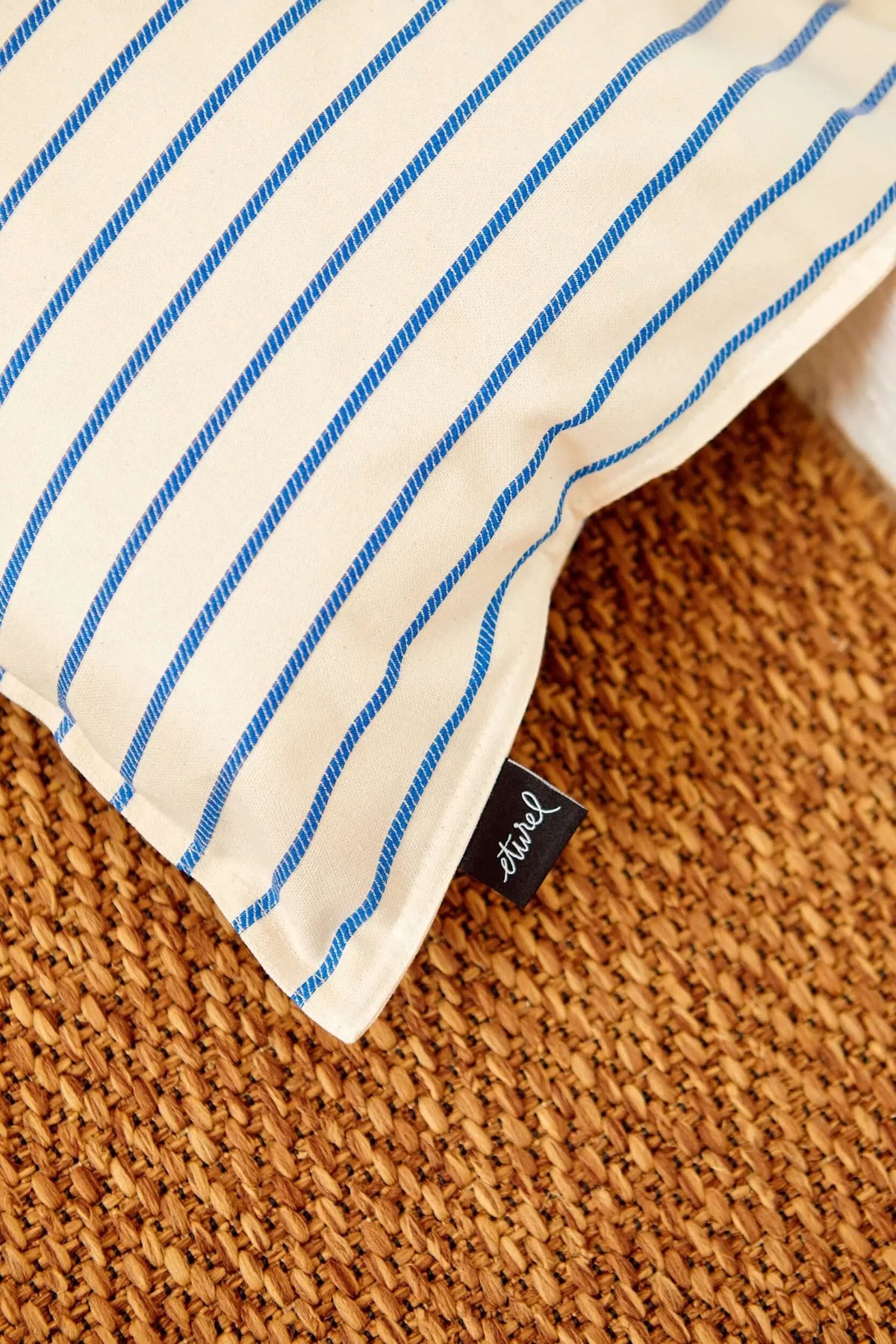 Funda de cojín rectangular de 30x50 cm con diseño de rayas azules sobre fondo crudo de tela estilo natural.
