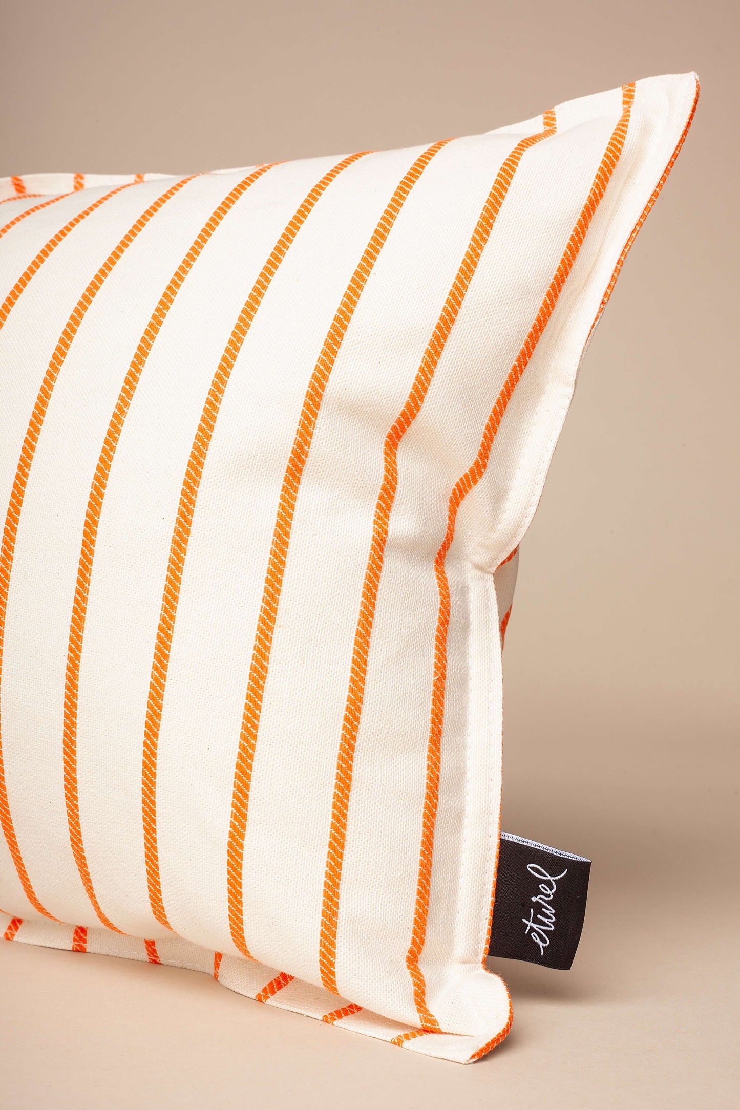 Funda de cojín rectangular de 30x50 cm, tela color crema con finas rayas verticales naranjas, estilo casual y minimalista.